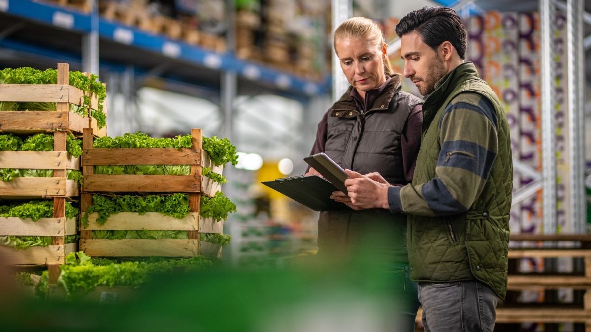 Two employees looking at a tablet in a warehouse