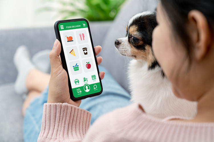 Over the shoulder of someone looking at their phone at produce.