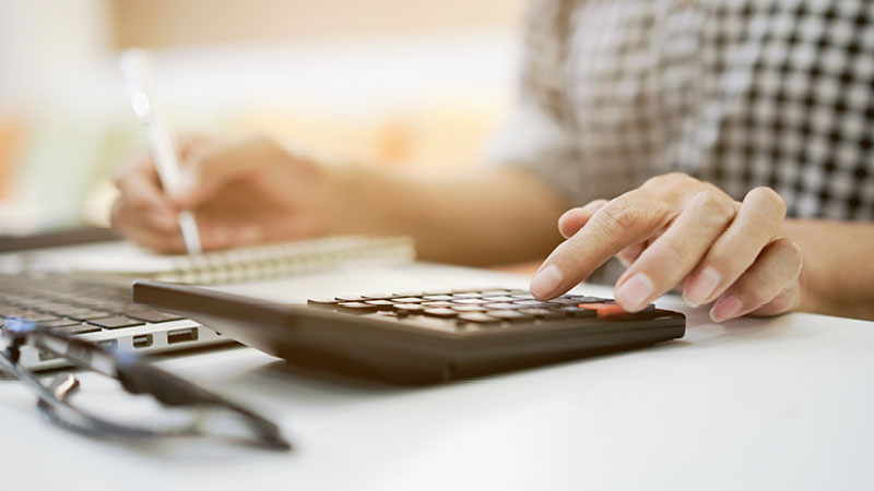 persona revisando cifras en una calculadora